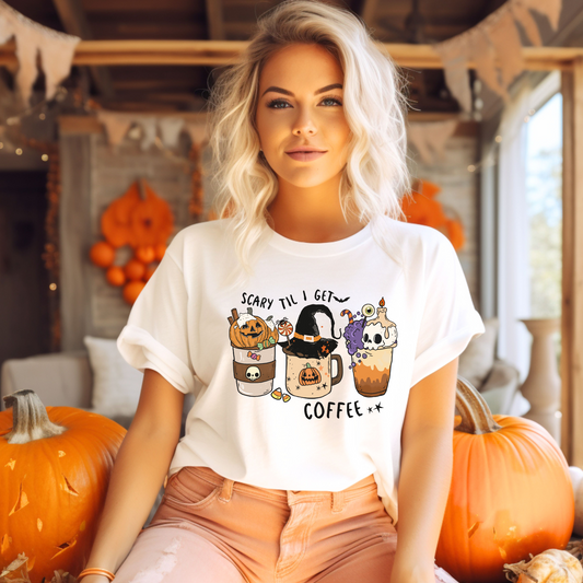 Tricou de Halloween reprezentând o ceașcă de cafea înconjurată de simboluri tematice precum lilieci și păianjeni, având inscripționat textul 'Scarry 'Til I Get Coffee'.